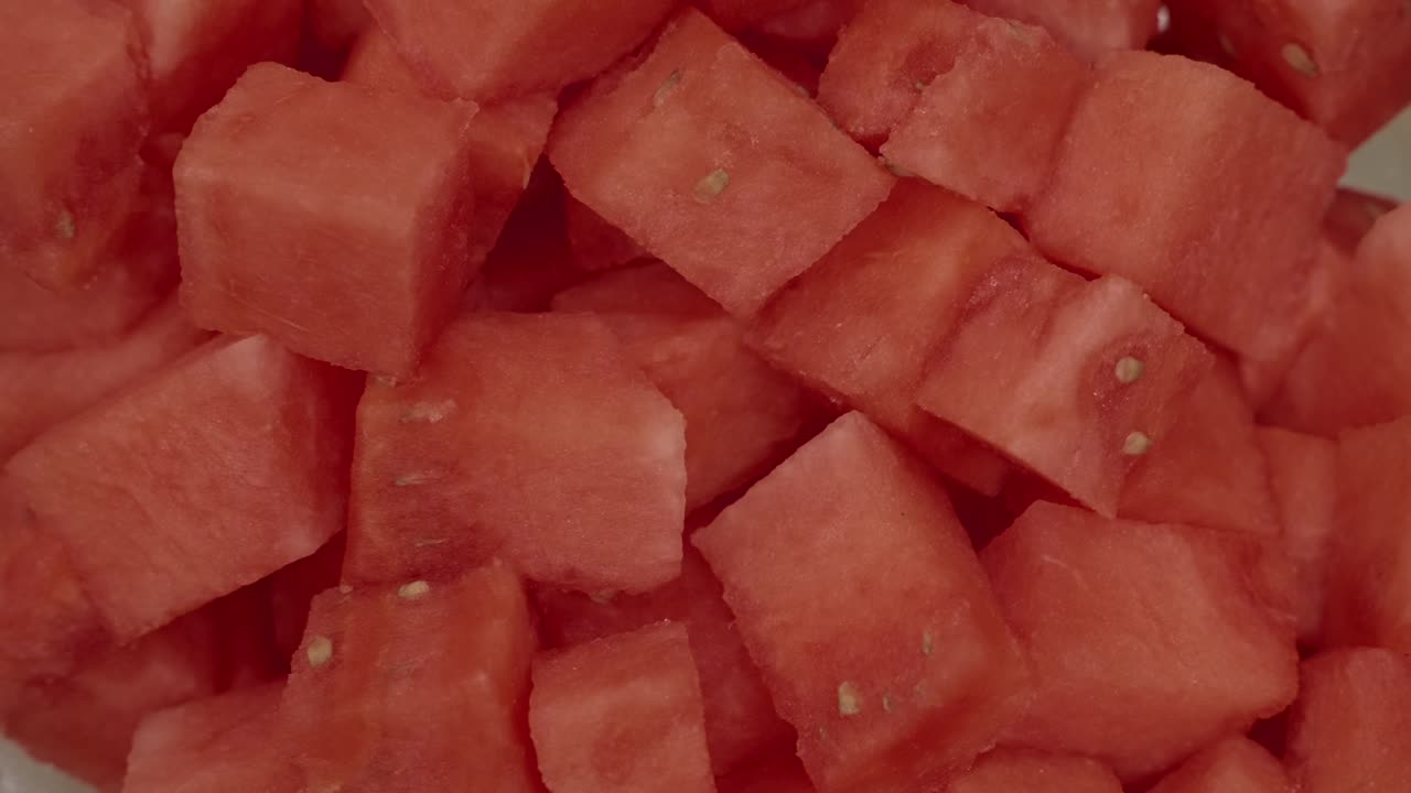여름에 시원하게 즐기기 좋은, 과즙이 풍부한 빨간색 텍스처를 보여주는 신선한 수박 큐브의 클로즈업 사진이에요