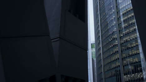 reflection of the gherkin building on the shiny, mirror-finished windows of another skyscraper in the city of london - wide panning shot