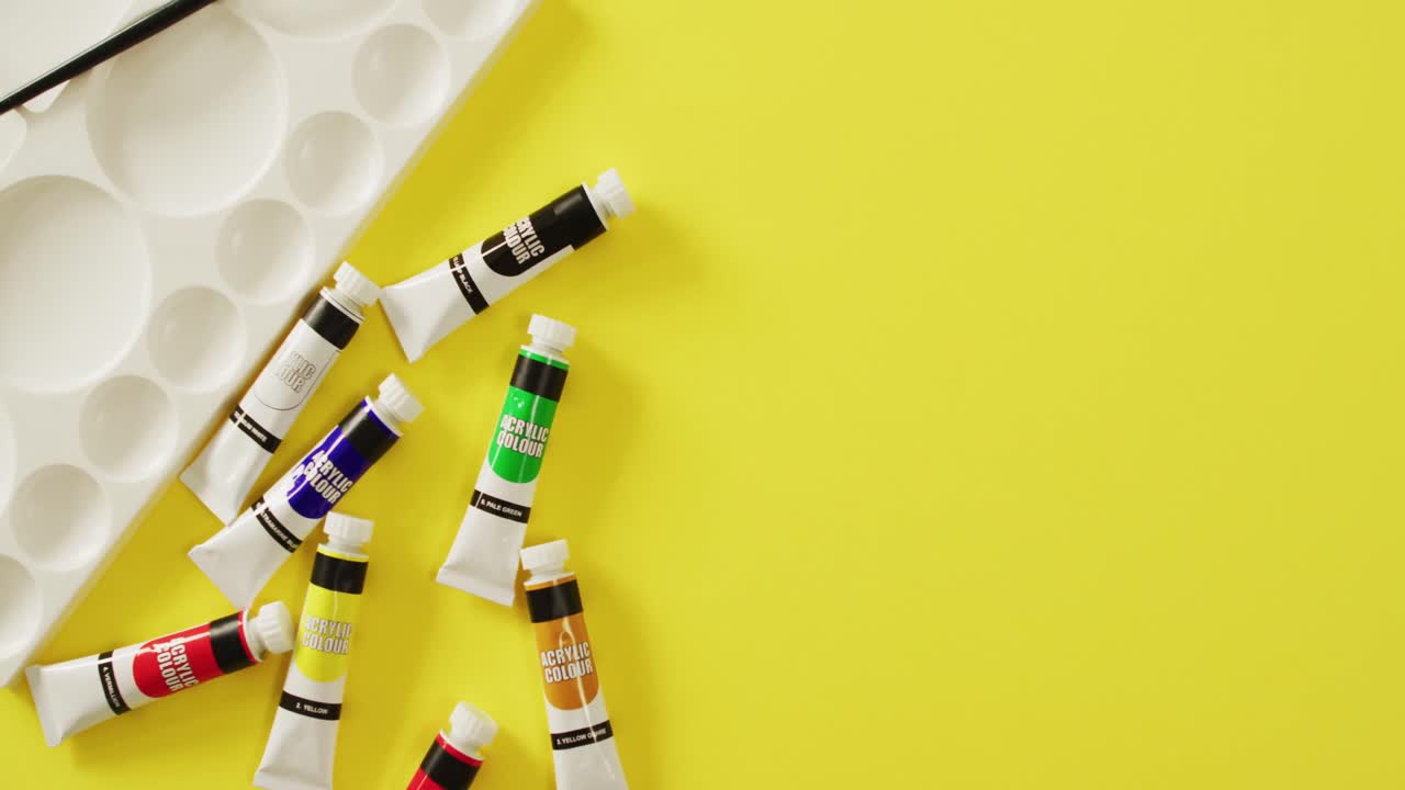 노란색 배경에 복사 공간을 가진 바지, 브러시 및 팔레트의 비디오