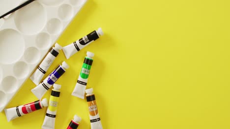 video de pantalones, pincel y paleta con espacio de copia en fondo amarillo