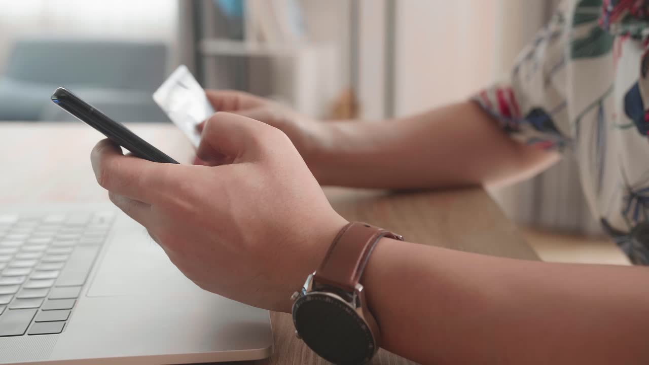 Close Up Of Man Hand Holding Smartphone And Credit Card And Doing Online Shopping At Home. Banking, Online Shopping And Lifestyle Concept