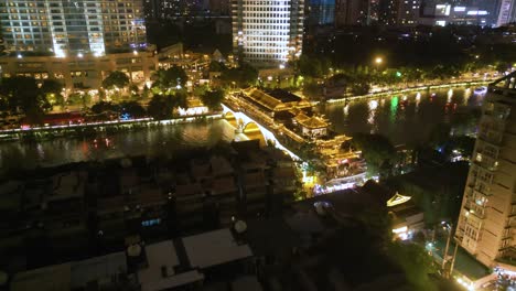 Vista-Aérea-De-Volar-Sobre-El-Famoso-Puente-Anshun-Y-El-Río-Fuhe-En-La-Noche-Con-Una-Hermosa-Iluminación-En-El-Centro-De-Chengdu,-China