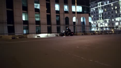 Stylish-rider-starts-on-motobike,-making-wide-turn-on-the-street-road-at-night