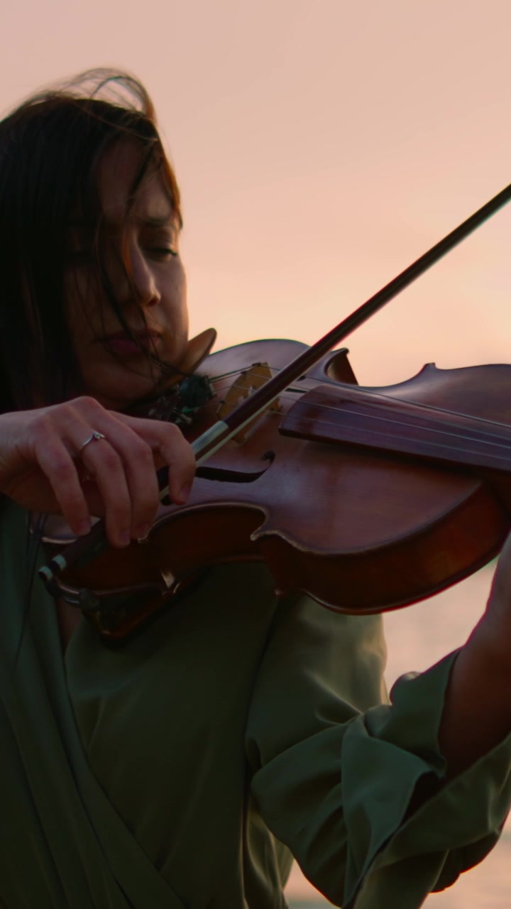 Young Woman Playing Violin Outdoors at Sunset
