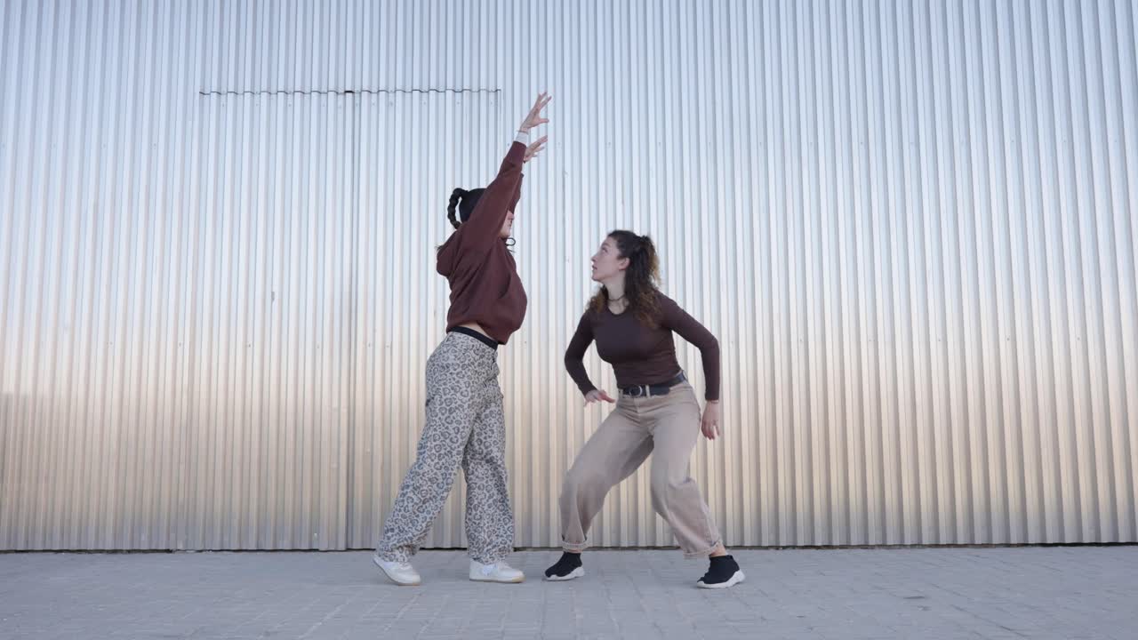 Energetic female dancers performing choreography in urban setting