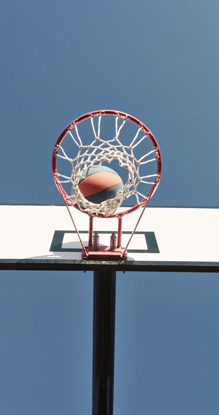 Giocatore di basket che fa canestro contro un cielo azzurro limpido