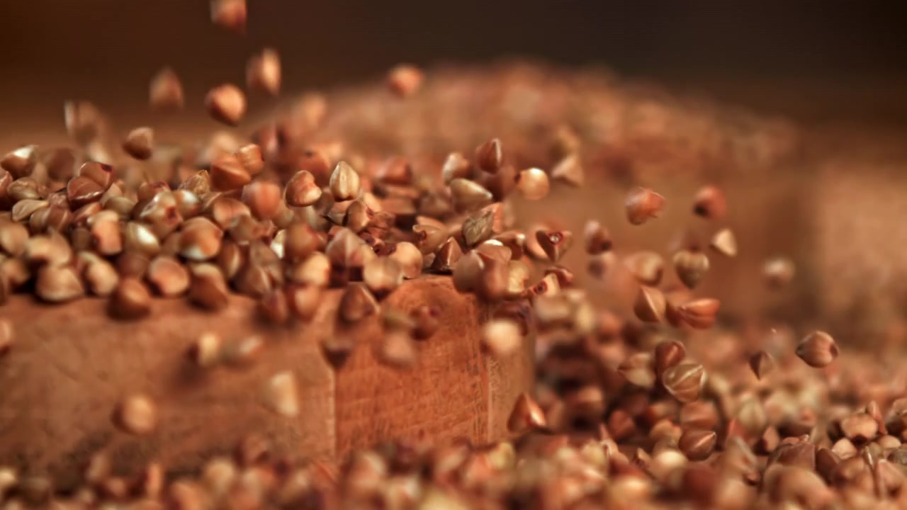Slow Motion of Buckwheat Grains Falling onto a Wooden Background