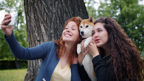 friends taking a selfie with a dog in a park