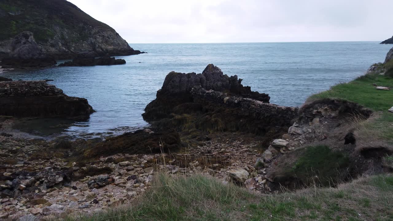 exploración urbana en el borde de la costa galesa erosionada con vistas a la playa de rocas ásperas y al mar irlandés