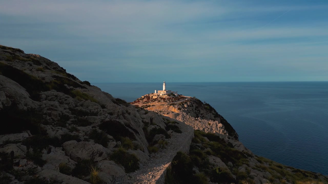 Iconico faro di Cap de Formentor con scogliere drammatiche, montagne e formazioni rocciose al tramonto. Bellezza naturale del mare blu profondo sull'isola delle Baleari Palma di Maiorca. Riprese aeree epiche con drone in 4K UHD