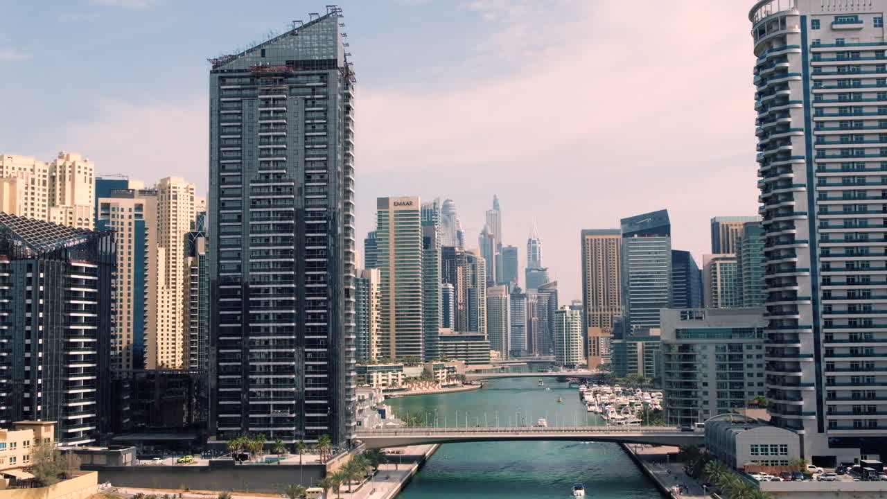Vista panoramica del porto turistico di Dubai con yacht che navigano nel canale e moderni grattacieli che svettano su entrambi i lati