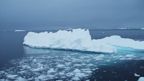 Aerial-drone-shot-of-Antarctica-Icebergs,-Ice-Formations-of-Beautiful-Winter-Icebergs-Floating-in-the-Blue-Southern-Ocean-Sea-Water-on-the-Antarctic-Peninsula-on-a-Zodiac-Boat-Tour-Excursion