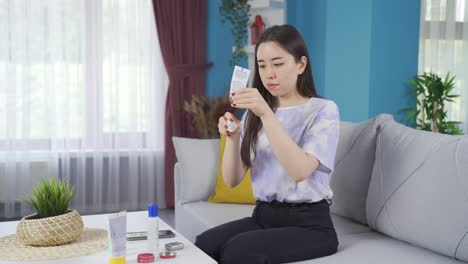 asian teenage girl applying cream to her hands, doing personal care.