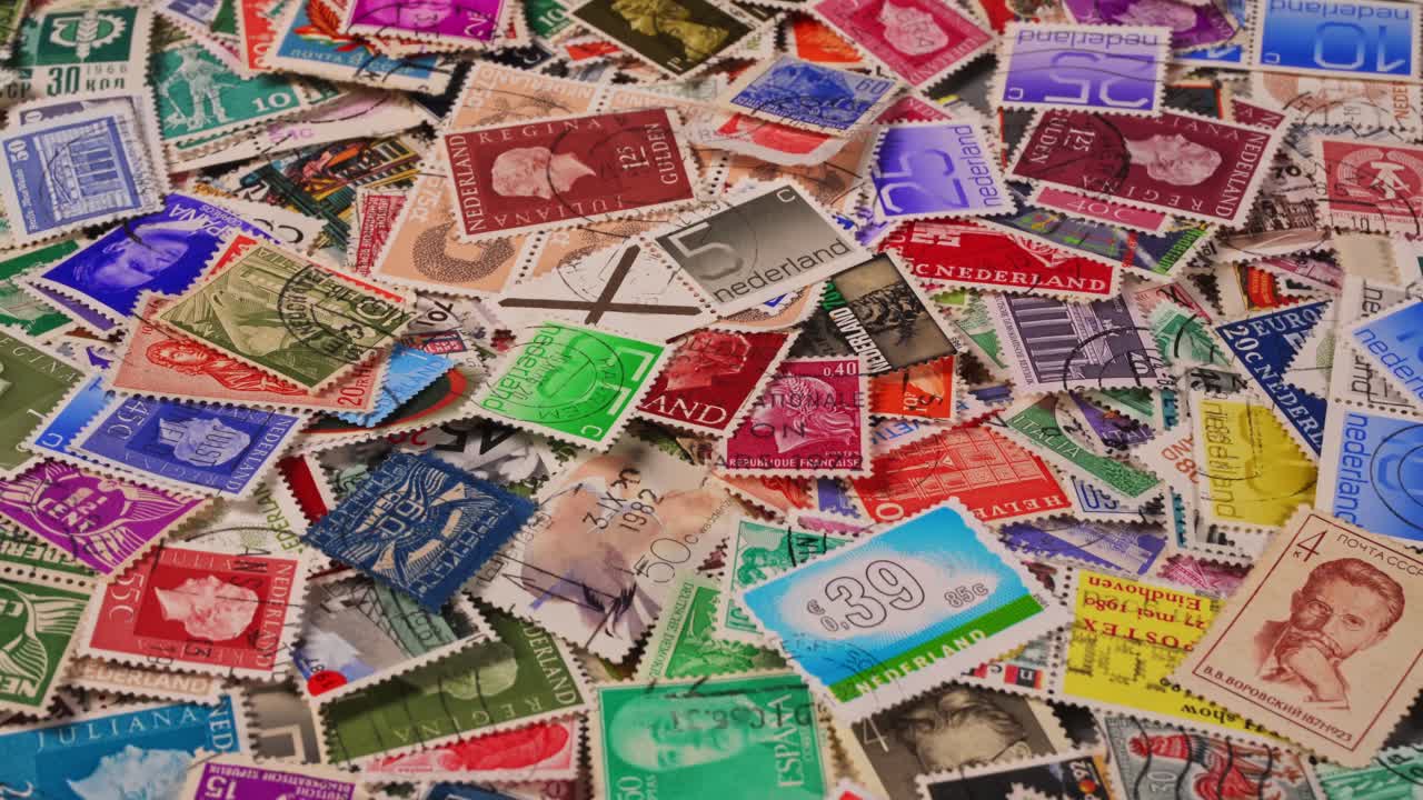 Coleção de selos coloridos de vários países espalhados sobre uma mesa