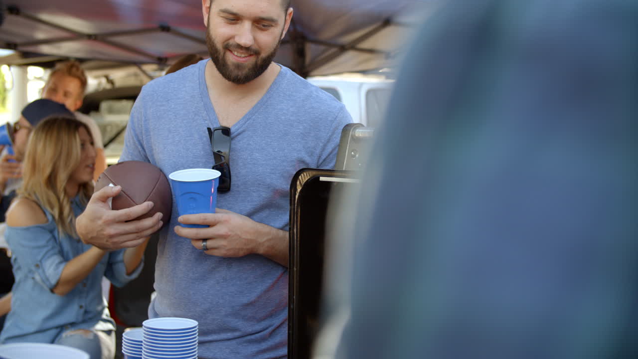 Slow Motion Shot Of Sports Fans Tailgating In Parking Lot