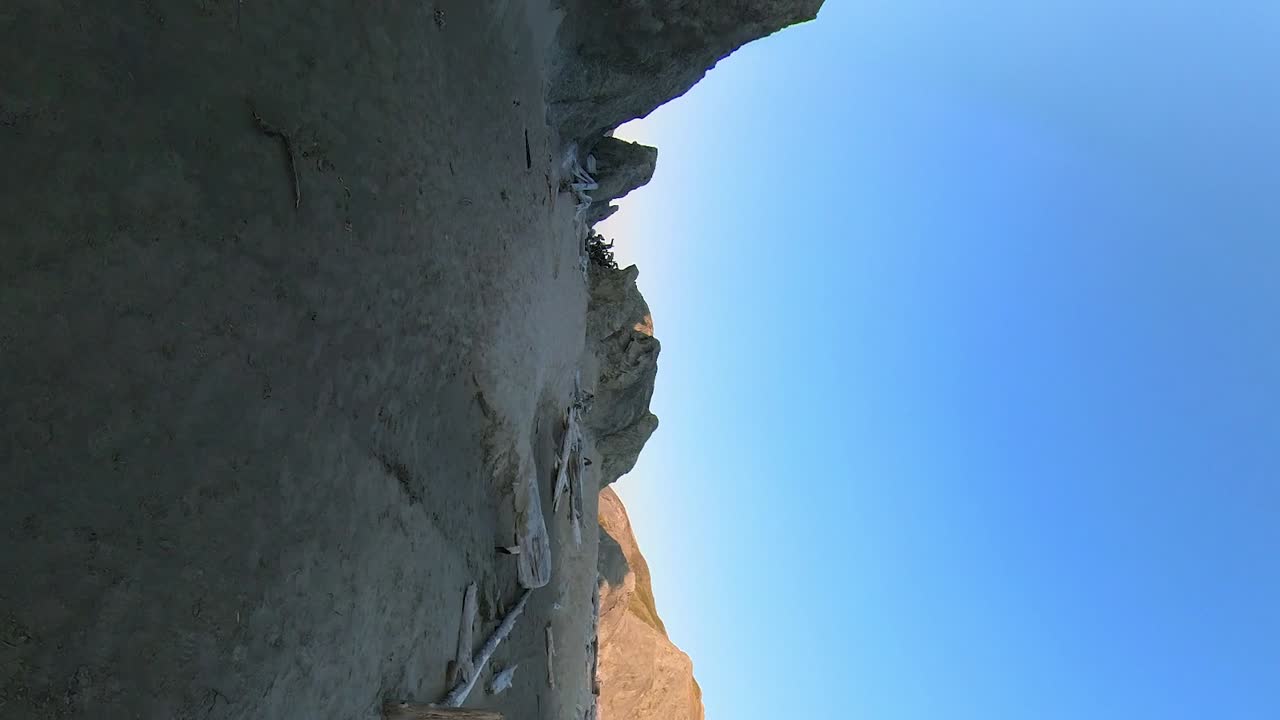 밴든 해변에 카메라를 들고 있는 백패커의 세로 샷