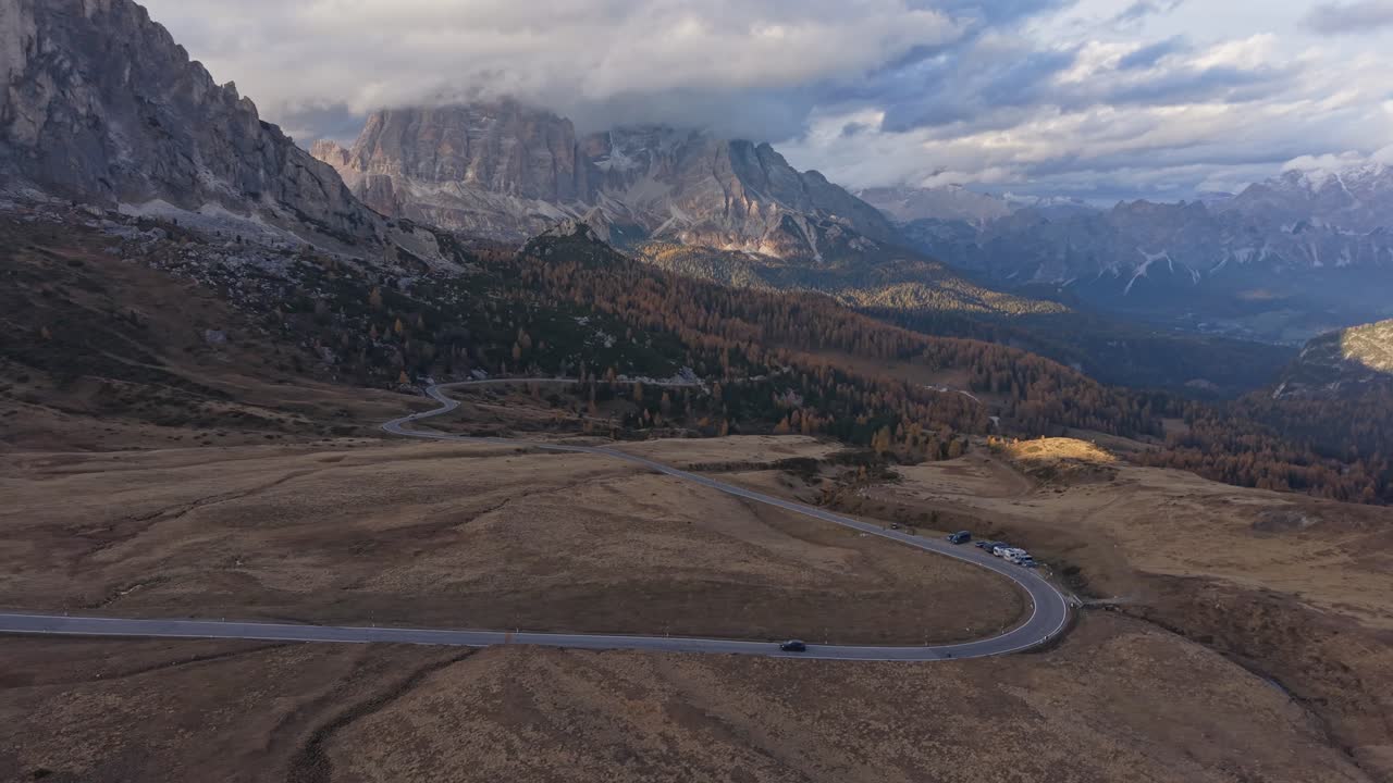 Luftfoto af køretøjer på den naturskønne Passo Giau-vej om efteråret, Dolomitterne, Italien