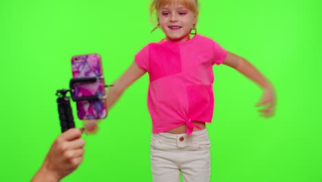 Dancing-young-little-kid-girl-blogger-record-dance-moves-at-camera-for-social-media-content-on-phone