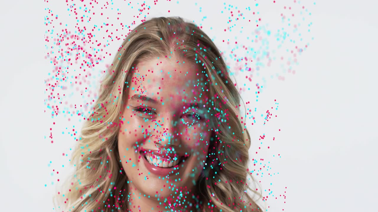 Model smiling causing magenta or cyan particles sweeping face into ribbon dispersing for beauty ad