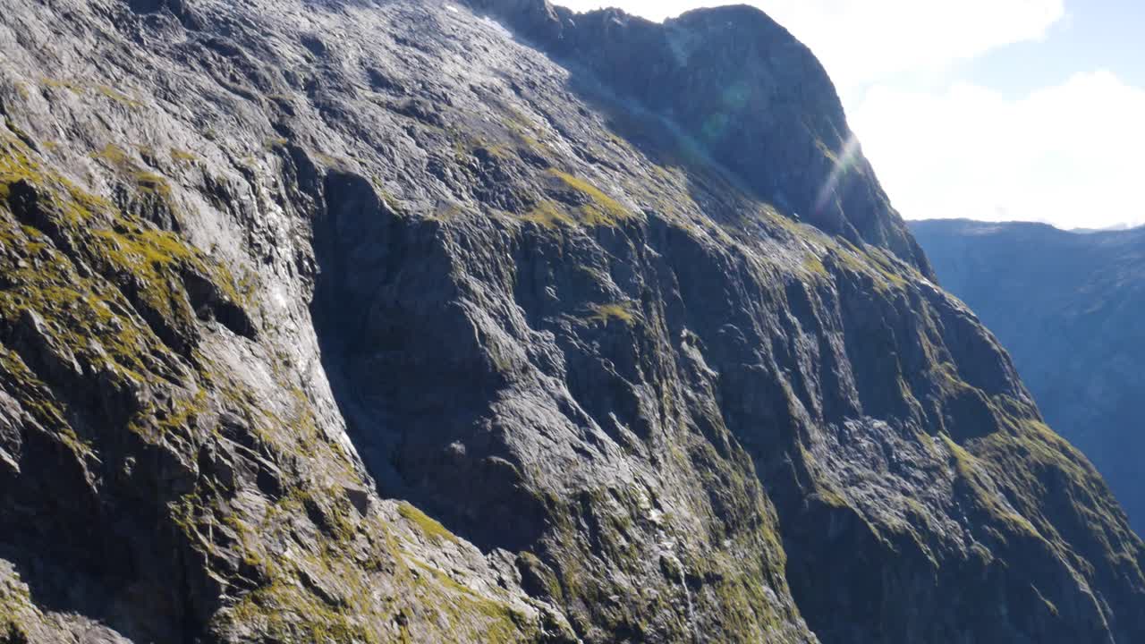 gertrude 안장 하이킹 경로에서 밝은 햇빛 동안 가파른 바위 산 벽의 패닝 샷 - 공중 보기