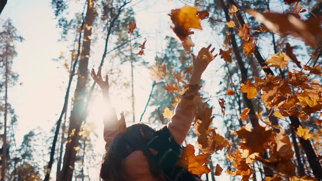 숲 에서 가을 잎 을 즐기는 여자