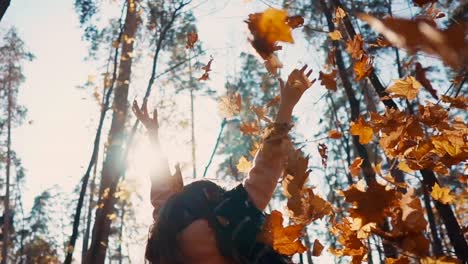 woman enjoying autumn leaves in the forest