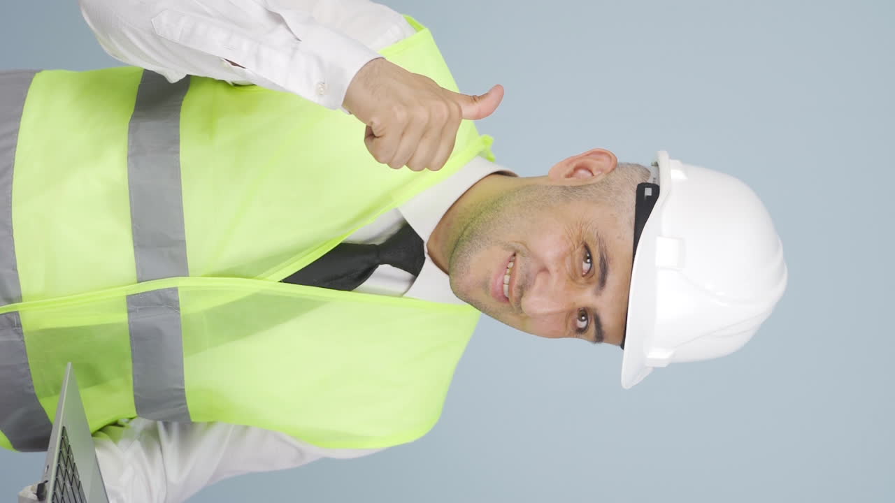 ⁇ 탑을 들고 카메라를 보며 웃는 엔지니어의 수직 비디오.