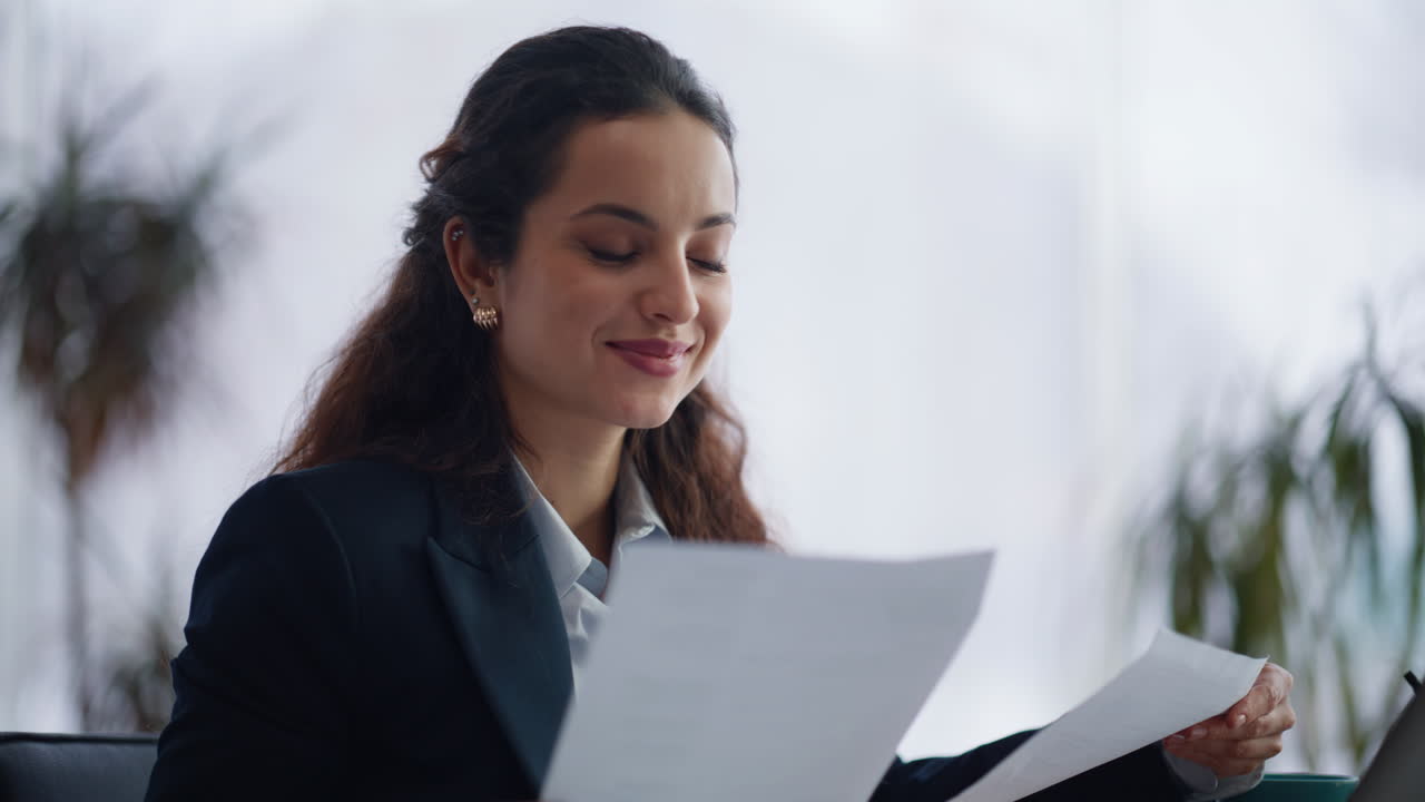 Closeup lawyer texting laptop flipping documents at panorama window cabinet