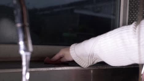 superficies de limpieza a mano en la cocina plano medio
