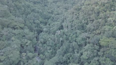 slow pan above brazilian waterfall in amazon rainforest to reveal sunset over mountain