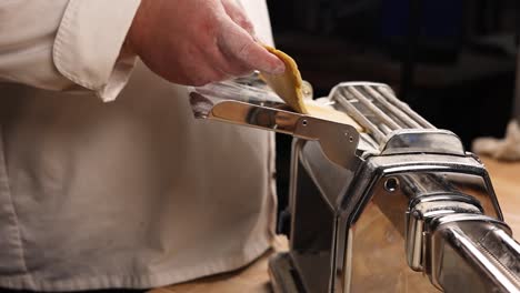 chef making pasta with a pasta machine