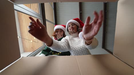 dos chicas emocionadas abriendo una caja de regalos de navidad