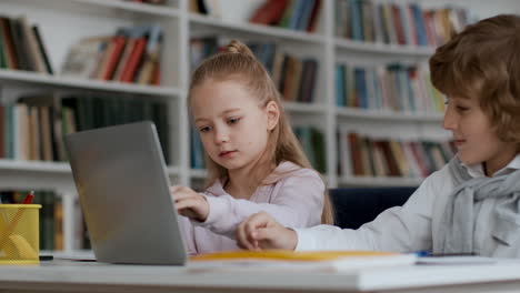 children learning on laptop in library