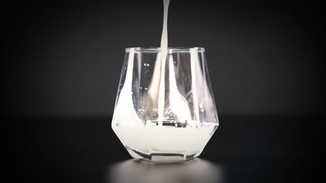 milk being poured into a clear glass