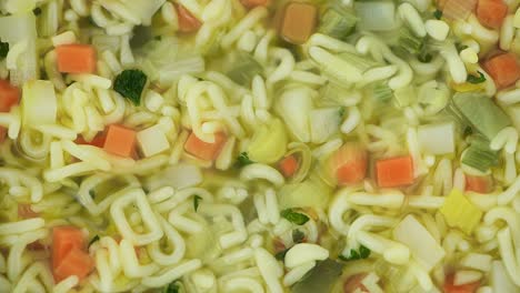 sopa de alfabeto con verduras en un plato giratorio (con bucle sin costuras)