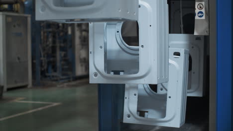 Washing machine body moving on conveyor line at production plant