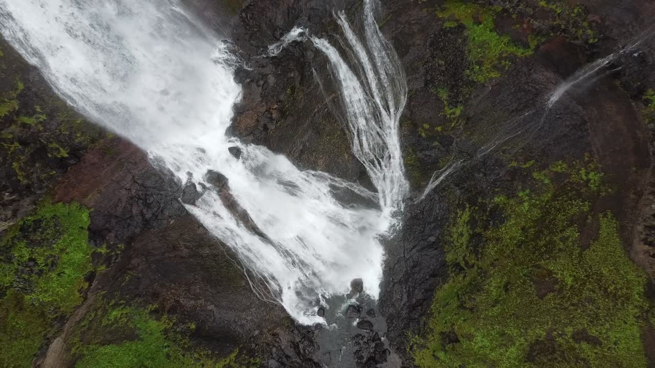 toma aérea de la caída de la cascada de glymur en islandia durante el día nublado