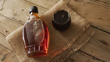 video of maple syrup in bottle and fabric on wooden surface