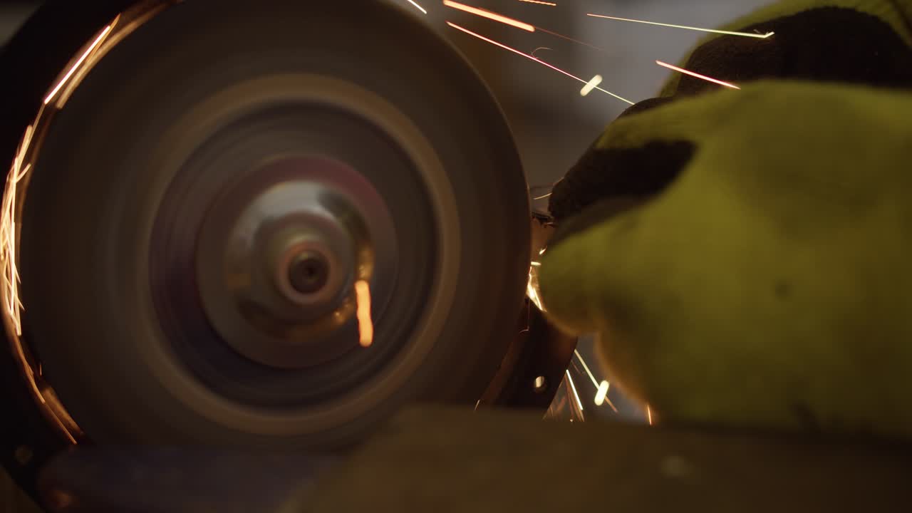 벤치 그라인더에 의해 모양이 바뀌는 금속의 측면 보기, 점화 불꽃 4k 느린 동작