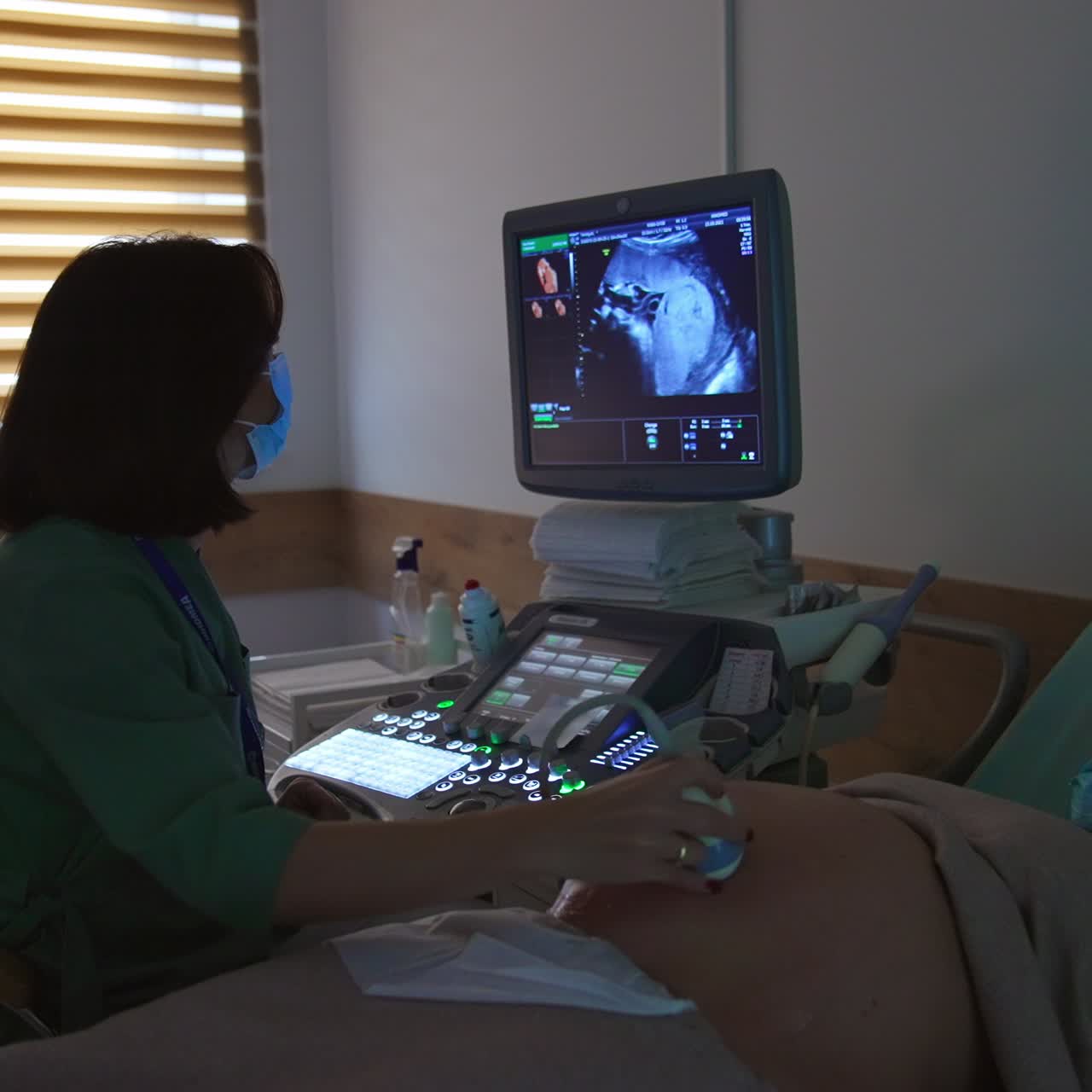 Ultrasound screening of pregnancy on the final stage. Young expecting woman is having doctor's examination at modern clinic