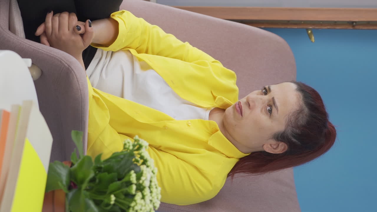 창 밖을 지켜보는 감정적 인 여성의 수직 비디오.