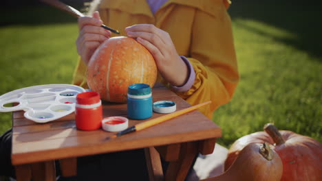 un niño decora una calabaza - prepara decoraciones festivas