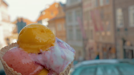 vista en cámara lenta del paisaje urbano desenfocado en el fondo y luego se ven bolas de helado en la taza de gofres de praga república checa