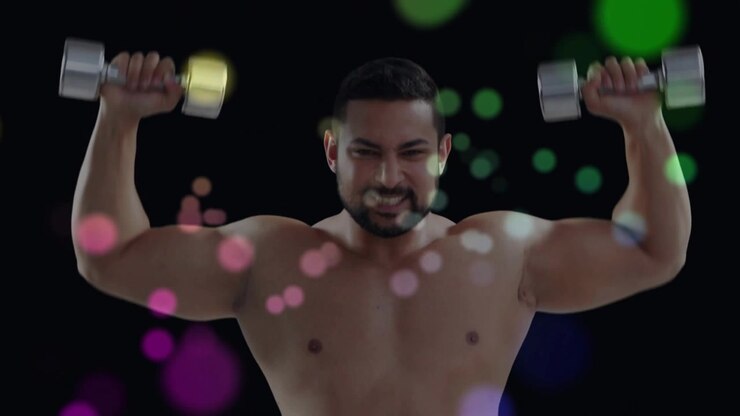 Fitness coach raising arms gripping dumbbells pressing up training shoulders with bokeh overlay