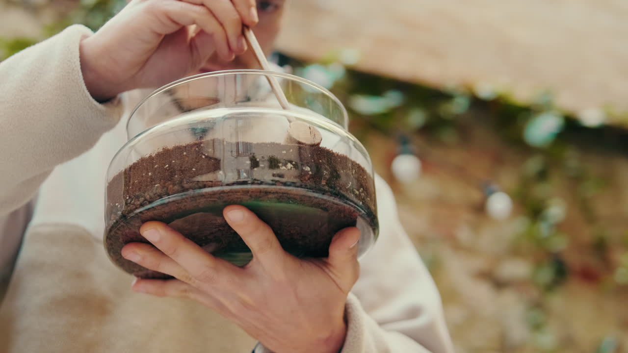 Close-up of Hands Creating a Miniature Terrarium Garden