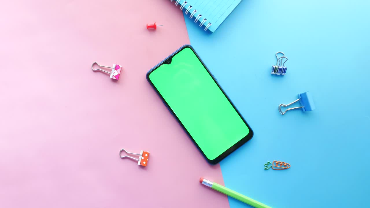 acostado con teléfono inteligente y suministros escolares