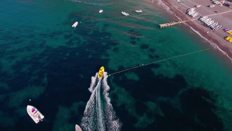 aerial drone shot tilt up following boat into positano beach, italy