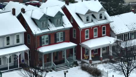 long aerial zoom of cute snow covered town houses