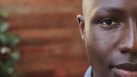halfportrait of happy african american man smiling on outdoor terrace, copy space, slow motion