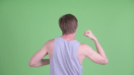 back view portrait of caucasian man shot against green studio background